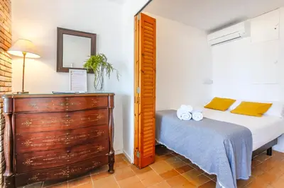 a bedroom with a bed and a wooden dresser at Penelope Apart in Sitges