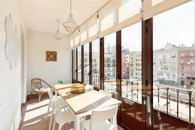 an apartment with a balcony with a table and chairs at Verdaguer Apartments by Central in Barcelona
