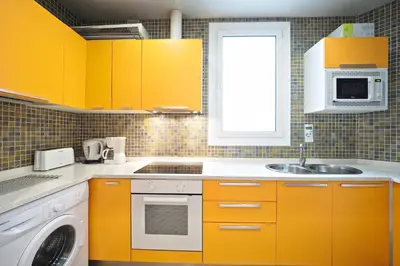 a kitchen with yellow cabinets and a sink at Suites4days Sagrada Familia Apartment in Barcelona