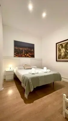 a bedroom with a large bed with a painting on the wall at Suites4days Sagrada Familia Apartment in Barcelona