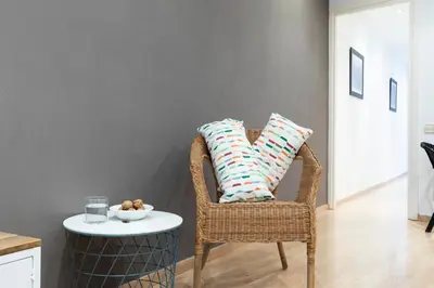 a wicker chair with two pillows and a table at AB Princep Jordi in Barcelona