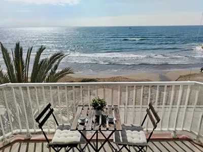 a table and chairs on a balcony overlooking the ocean at Port Alegre Mar in Sitges