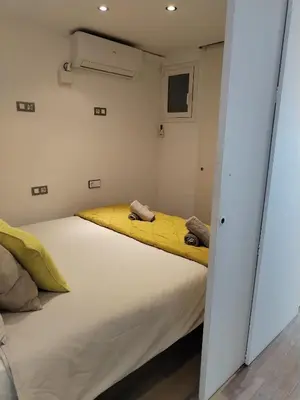 a bedroom with a large bed with yellow sheets at Port Alegre Mar in Sitges