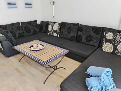 a living room with a black couch and a table at Port Alegre Mar in Sitges