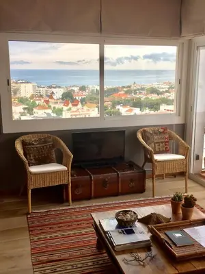a living room with two chairs and a large window at Sea Views Penthouse in Sitges