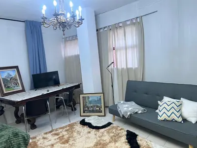 a living room with a blue couch and a desk at Tessasapartments Sabadell 4 in Sabadell