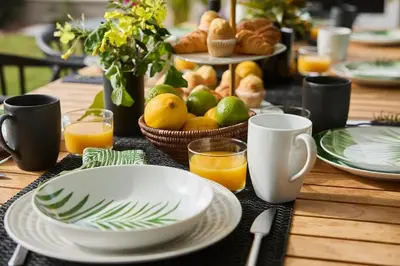 a table topped with plates and bowls of fruit and orange juice at Villa Sitges Casa Selva 7 minutos de Sitges en coche Diseño Comodidad Nueva Ideal para Vacaciones in Sant Pere de Ribes