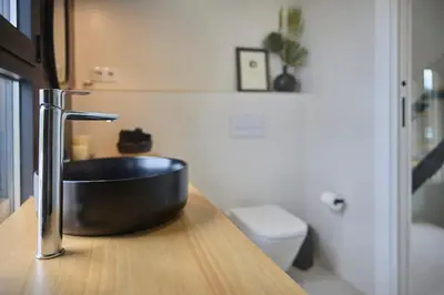 a bathroom with a black sink on a wooden counter at Villa Sitges Casa Selva 7 minutos de Sitges en coche Diseño Comodidad Nueva Ideal para Vacaciones in Sant Pere de Ribes