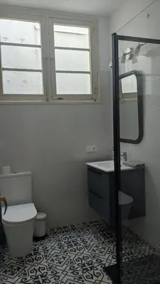 a bathroom with a toilet and a sink and a mirror at Centric apartment 100m from the beach in Mataró