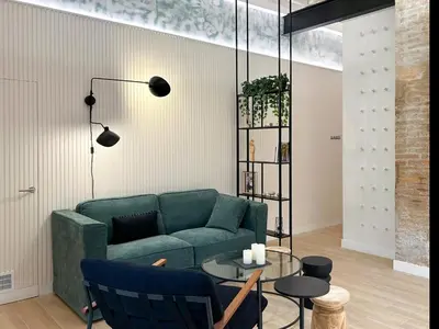 a living room with a green couch and a table at Apartment Gaudi in Vilanova i la Geltrú