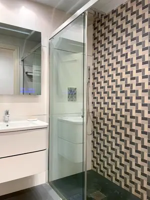 a bathroom with a glass shower and a sink at Apartment Monet in Vilanova i la Geltrú