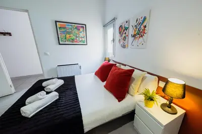a bedroom with a bed with red and yellow pillows at rentBCN Paseo de Gracia Apartments in Barcelona