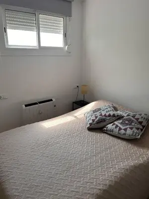 a bed in a white room with a window at Apartment by the sea in Cubelles in Cubelles