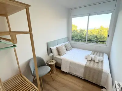 a small bedroom with a bed and a window at Atico Barcelona Playa in Sant Adria de Besos