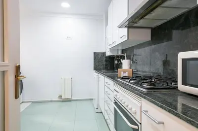 a kitchen with white cabinets and a stove top oven at Alcam Mallorca 22 in Barcelona