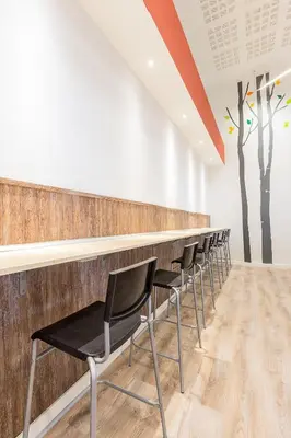 a row of chairs lined up at a bar at Ant Hostel Barcelona in Barcelona