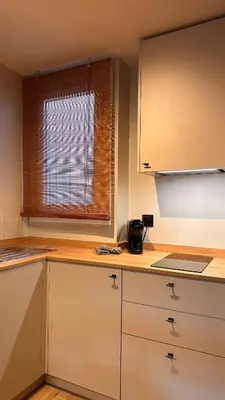 a kitchen with white cabinets and a window at La Fira - Paralelo 2 in Barcelona