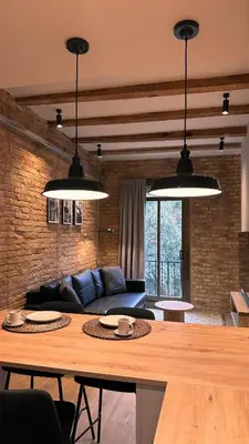 a living room with a table and two lights at La Fira - Paralelo 2 in Barcelona