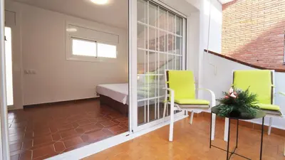 a room with two chairs and a bed and a table at SeaHomes Vacations - Villa Chill & Pool 200m Beach in Pineda de Mar