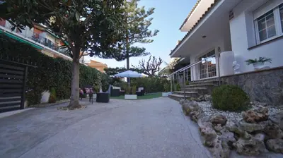a house with a tree and a building at SeaHomes Vacations - Villa Chill & Pool 200m Beach in Pineda de Mar