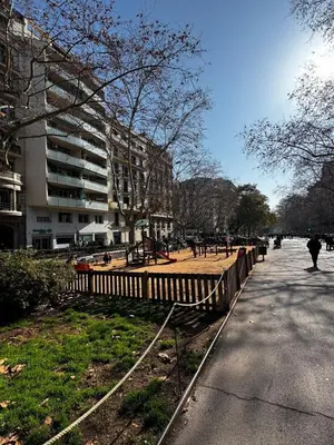 a playground in a park with a building in the background at Unique central home with large terrace & pool in Barcelona
