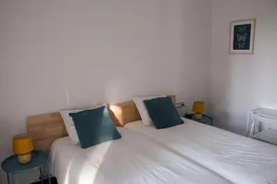 a bedroom with two twin beds and two tables at Apartamentos Villa Valle in Castelldefels
