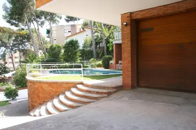 a brick house with stairs leading to a swimming pool at Apartamentos Villa Valle in Castelldefels