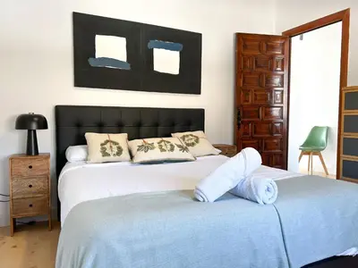 a room with a chair and a wall with pictures at PalmBreeze in Vilanova i la Geltrú