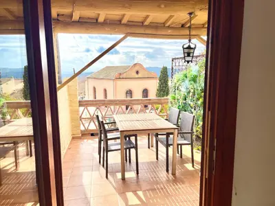 a balcony with a table and chairs and a church at Old Town Montserrat in Collbató