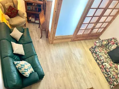 a living room with a green couch and a chair at Old Town Montserrat in Collbató