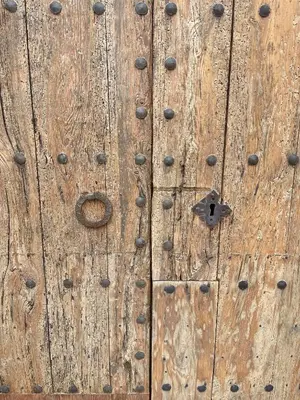 an old wooden door with a lock on it at Old Town Montserrat in Collbató