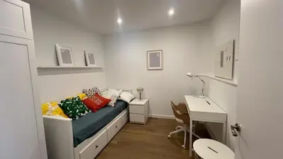a small bedroom with a bed and a desk at Piso Centro Badalona in Badalona