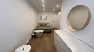 a small bedroom with a bed and a mirror at Piso Centro Badalona in Badalona