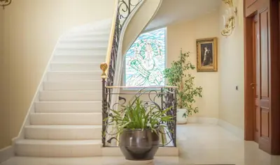 a staircase with a potted plant and a stained glass window at Hotel Boutique Edelweiss La Garriga in La Garriga