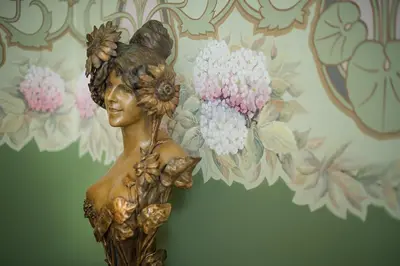 a statue of a woman holding flowers on a wall at Hotel Boutique Edelweiss La Garriga in La Garriga