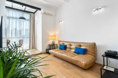 a living room with a brown couch and blue pillows at Sants Station Base 500Mb Wi-Fi AC in Barcelona