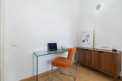 a glass desk with a chair and a laptop on it at Sants Station Base 500Mb Wi-Fi AC in Barcelona