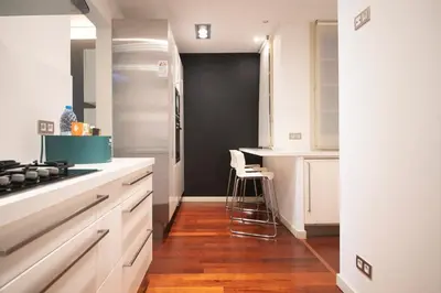 a kitchen with white cabinets and a black door at Apartamento de 3 habitaciones en Sant Antoni in Barcelona