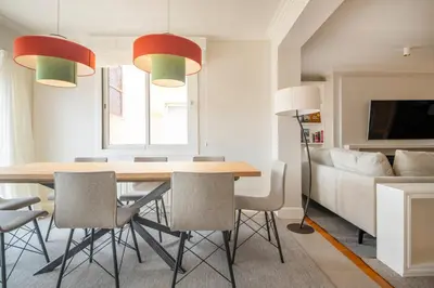 a dining room with a wooden table and chairs at Ático dúplex con cinco dormitorios in Barcelona