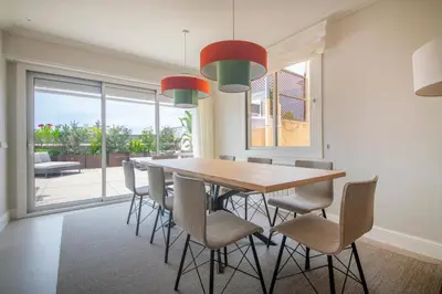 a dining room with a wooden table and chairs at Ático dúplex con cinco dormitorios in Barcelona