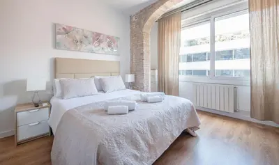 a bedroom with a large bed with two towels on it at Apartamento de cuatro dormitorios en Calle Aribau You Stylish Apartments in Barcelona