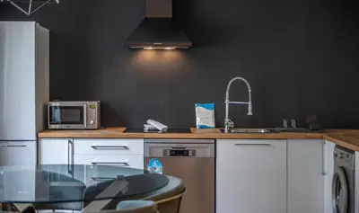 a kitchen with a counter with a sink and a microwave at Apartamento de cuatro dormitorios en Calle Aribau You Stylish Apartments in Barcelona