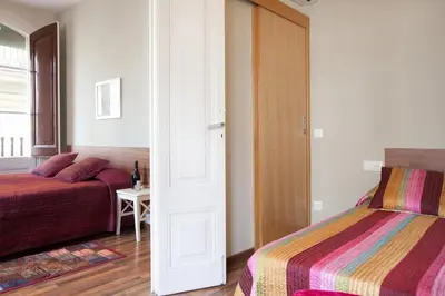 a bedroom with two beds and a door to a room at El Born Apartment - Santa Caterina Market - Walk to Cathedral & Picasso Museum in Barcelona