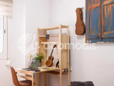 a room with a desk with a guitar on a wall at Great and nice 1 bedroom apartment close to Camp Nou in Barcelona