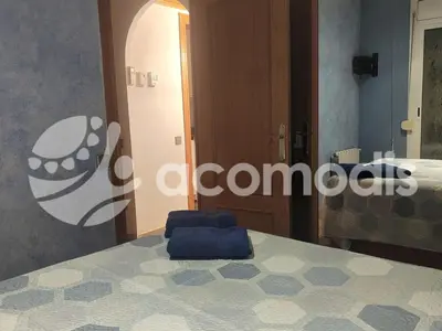 a blue chair sitting on a bed in a room at Passatge Concepcio in Hospitalet de Llobregat