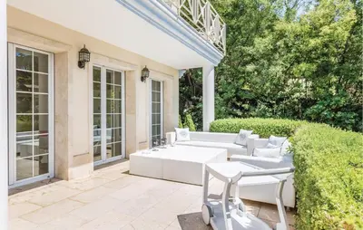 a patio with two white couches and a hedge at 5 Bedroom Amazing Home In Cabrils in Cabrils