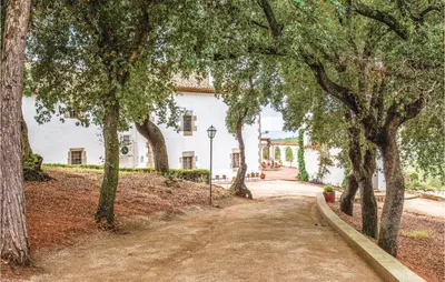 a dirt road with trees in front of a white building at Nice Home In Arenys De Munt in Arenys de Munt