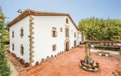 an exterior view of a white building with a courtyard at Nice Home In Arenys De Munt in Arenys de Munt