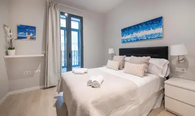 a white bedroom with a large bed with towels on it at Apartamento 4 dormitorios en Calle Roselló You Stylish Apartments in Barcelona