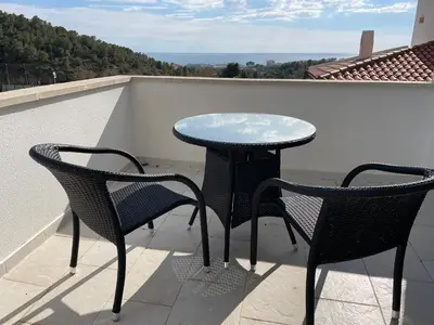 a garden with a stone wall and trees and plants at Entire villa with pool, ocean & mountain views in Sitges